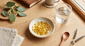 Castor oil soft gel capsules arranged on a wooden surface for digestive wellness